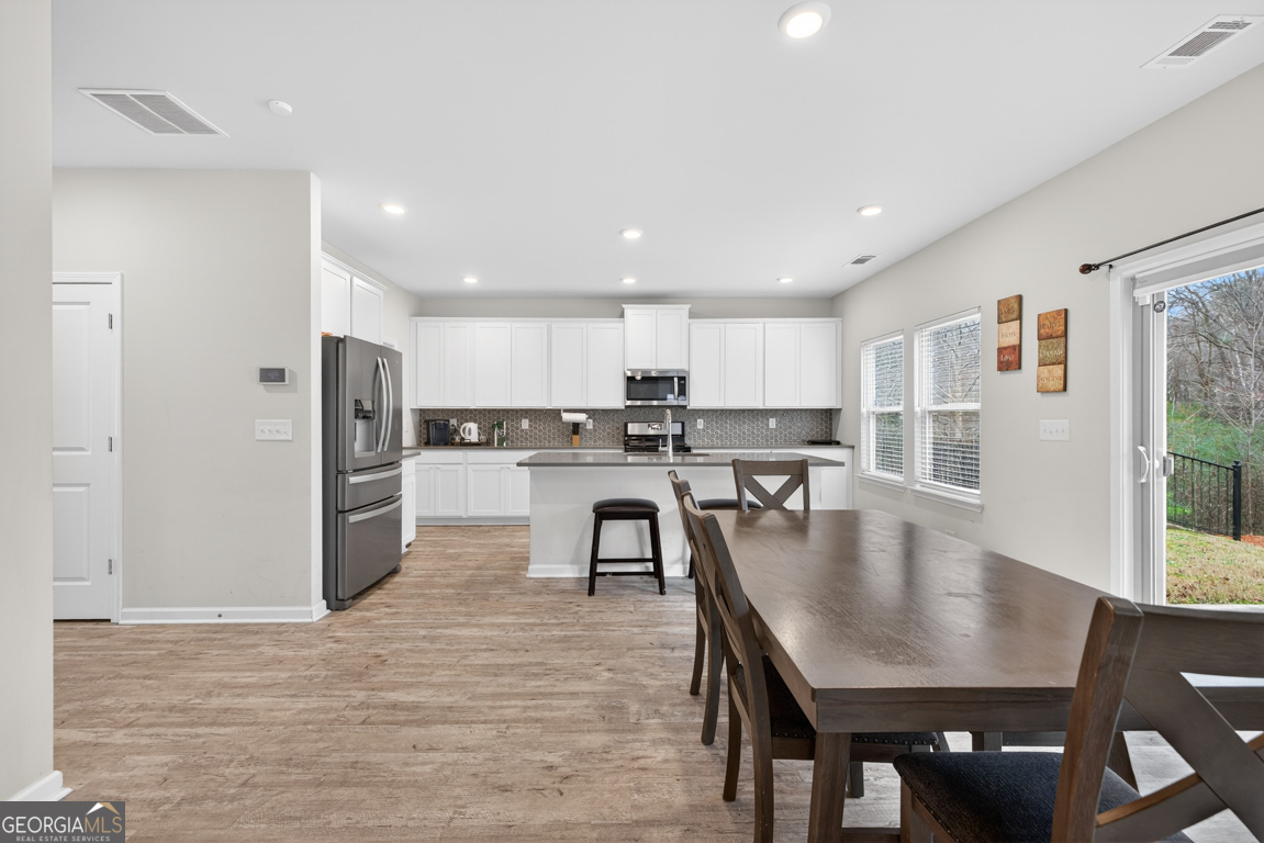 3511 Argent Way Marietta, GA 30008 - Photo 26 of 56 a kitchen with stainless steel appliances granite countertop a stove a refrigerator a kitchen island a table and chairs