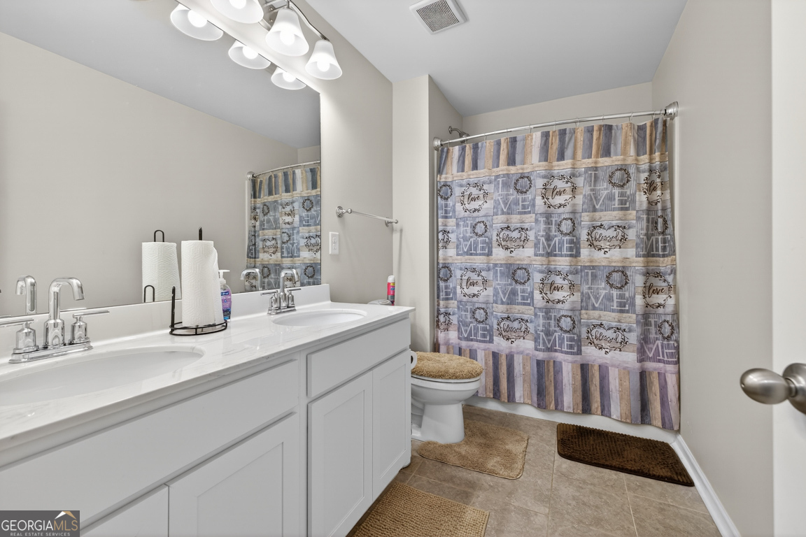 3511 Argent Way Marietta, GA 30008 - Photo 51 of 56 a spacious bathroom with a double vanity sink a toilet a mirror a vanity and shower