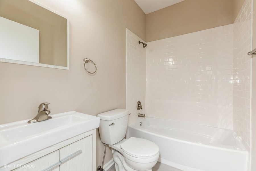 1431 West 108th Street, Unit D Chicago, IL 60643 - Photo 12 of 13 a white toilet sitting next to a bath tub