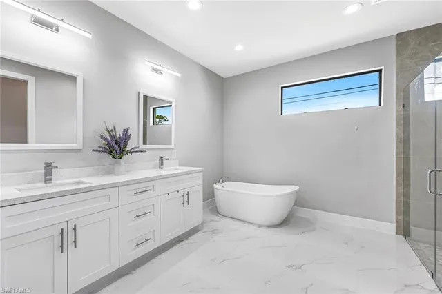 a spacious bathroom with a double vanity sink a toilet and a mirror