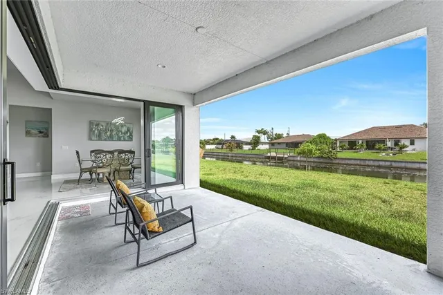 a view of a patio with a table chairs and garden