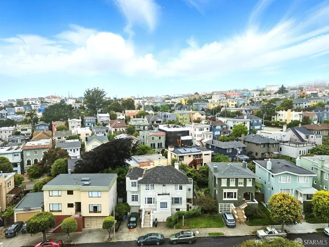 an aerial view of residential houses with city view