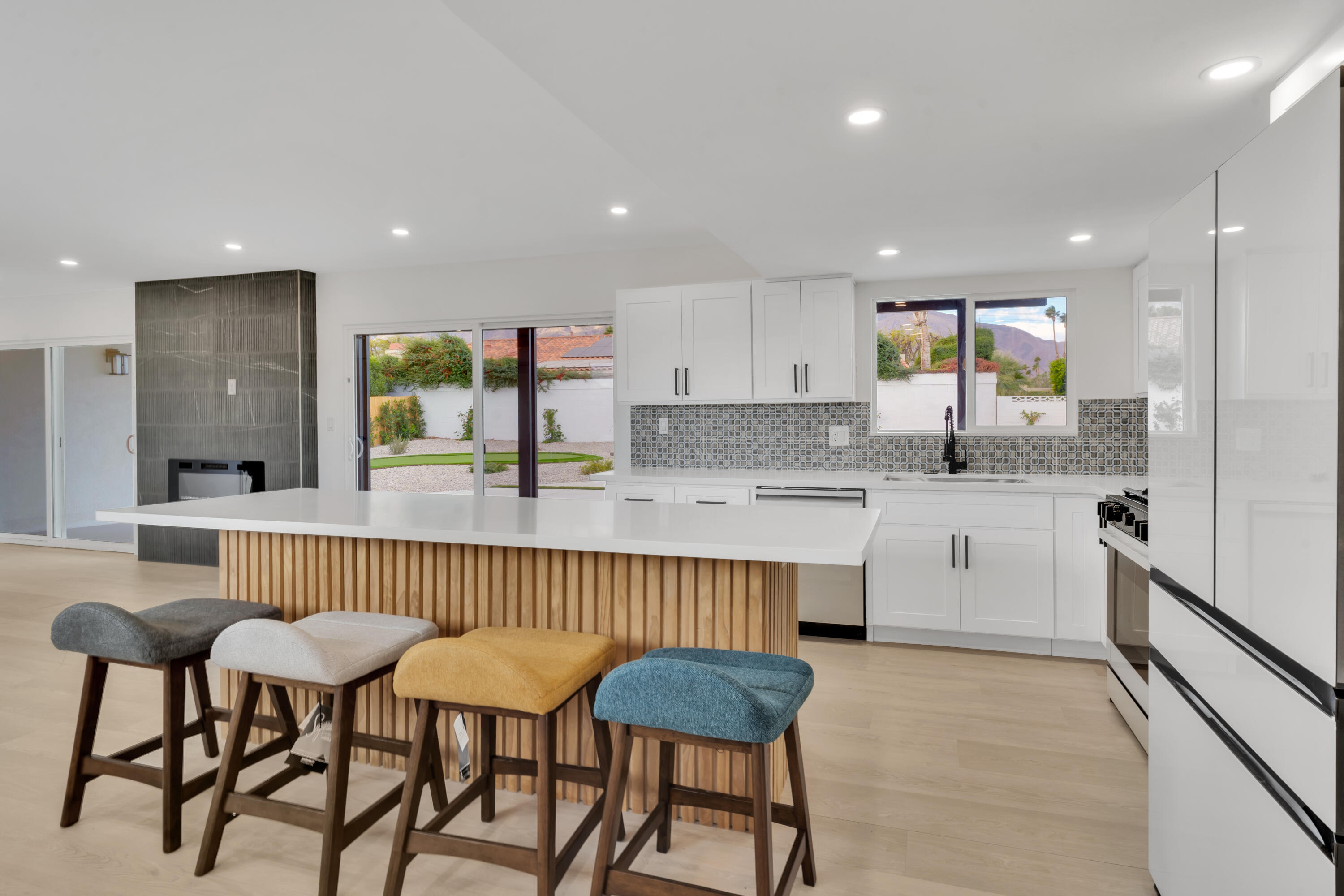 3087 North Biskra Road Palm Springs, CA 92262 - Photo 12 of 31 a kitchen with stainless steel appliances kitchen island granite countertop a kitchen island and chairs in it