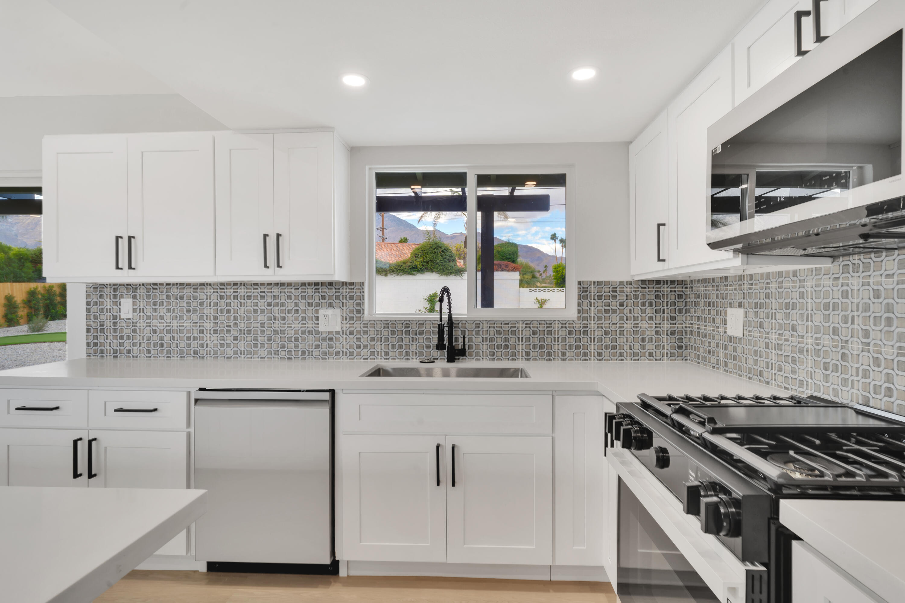 3087 North Biskra Road Palm Springs, CA 92262 - Photo 13 of 31 a kitchen with white cabinets and appliances