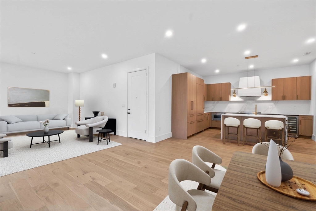 1114 Beacon Street, Unit 101 Newton, MA 02461 - Photo 1 of 29 a living room with lots of furniture and kitchen view