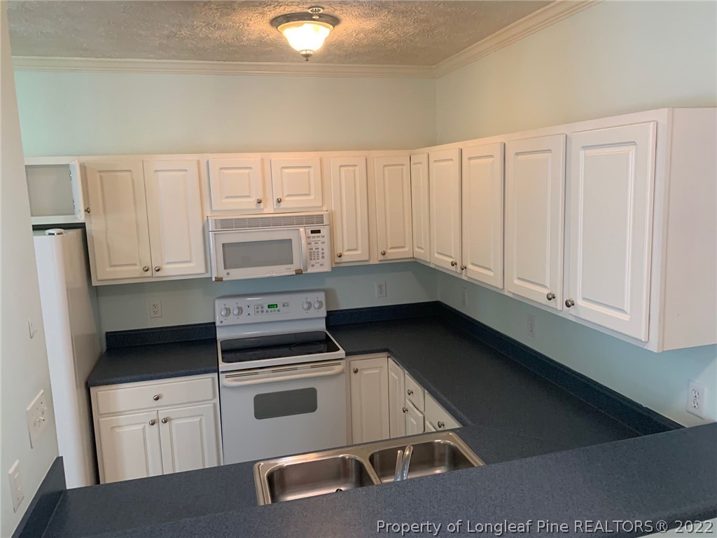 516 Lionshead Road, Unit 6 Fayetteville, NC 28311 - Photo 4 of 24 a kitchen with granite countertop white cabinets and white appliances