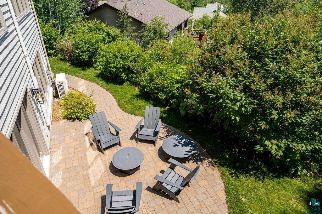 4856 Kingston Street Duluth, MN 55804 - Photo 77 of 88 Exterior hardscaping featuring a paver patio with a fire pit, surrounded by lush green landscaping and mature trees
