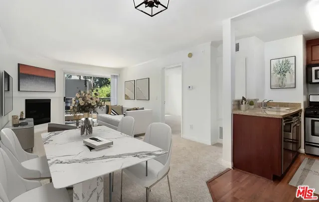 a living room with furniture a flat screen tv and kitchen view
