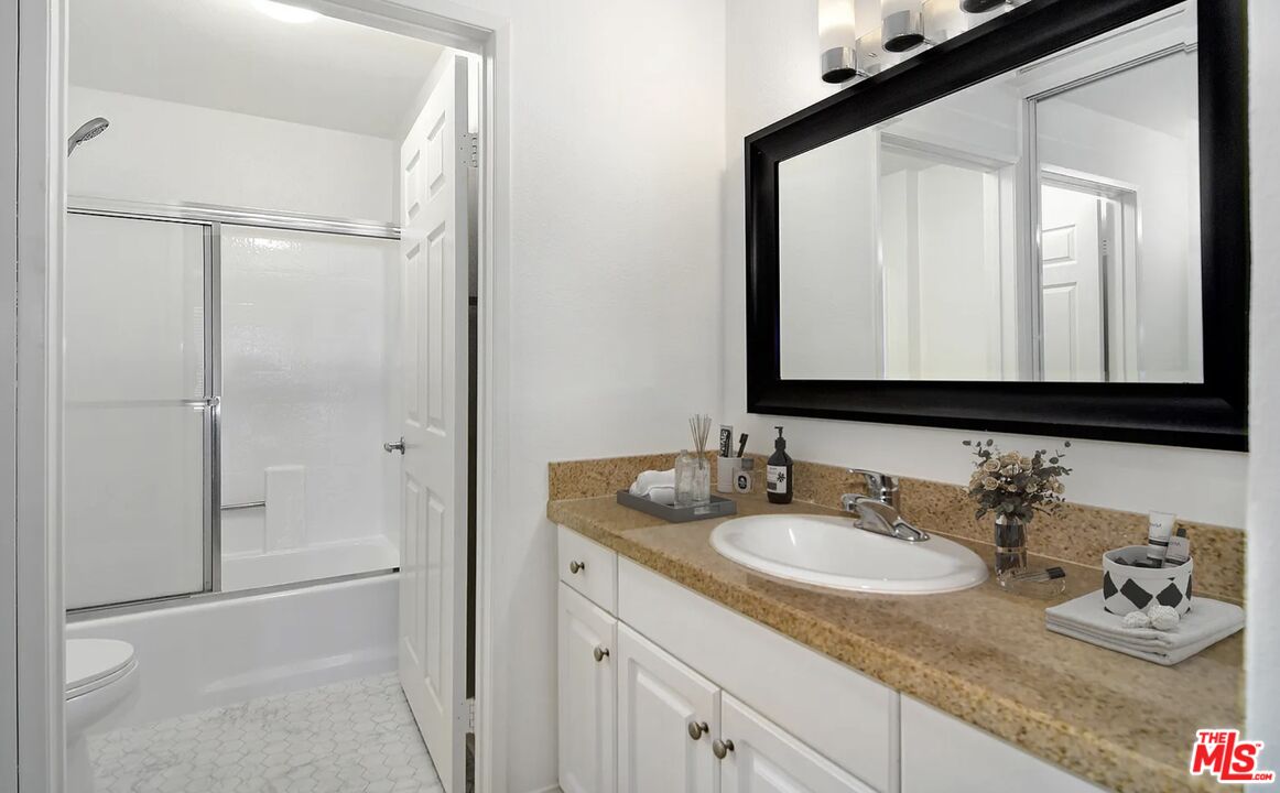 5545 Canoga Avenue, Unit 203 Woodland Hills, CA 91367 - Photo 9 of 12 a bathroom with a granite countertop sink and a mirror