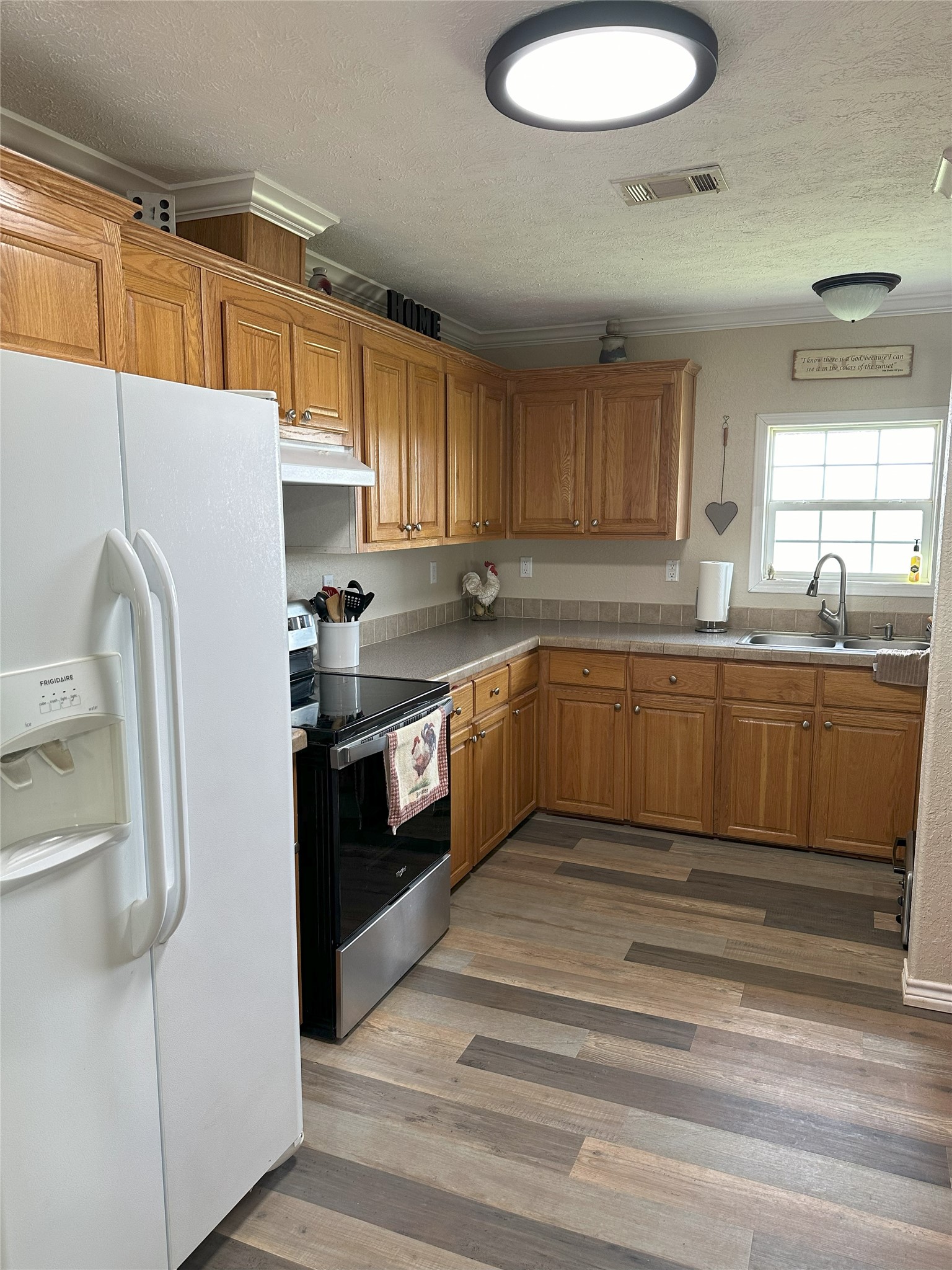 906 C R 235 Old Glory, TX 79540 - Photo 25 of 40 a kitchen with stainless steel appliances granite countertop a sink a stove a refrigerator and island with wooden floor