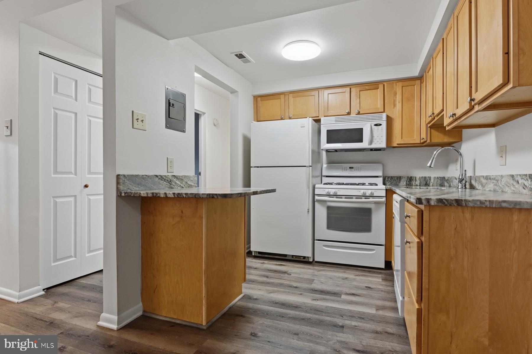 2570 Riva Road, Unit 3C Annapolis, MD 21401 - Photo 6 of 17 a kitchen with stainless steel appliances granite countertop a refrigerator a stove and a sink with wooden floor
