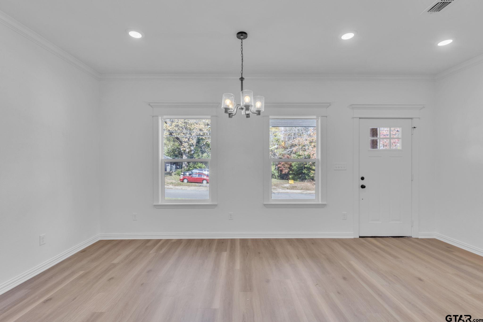 1410 West Connally Street Tyler, TX 75701 - Photo 11 of 29 an empty room with window chandelier fan and windows