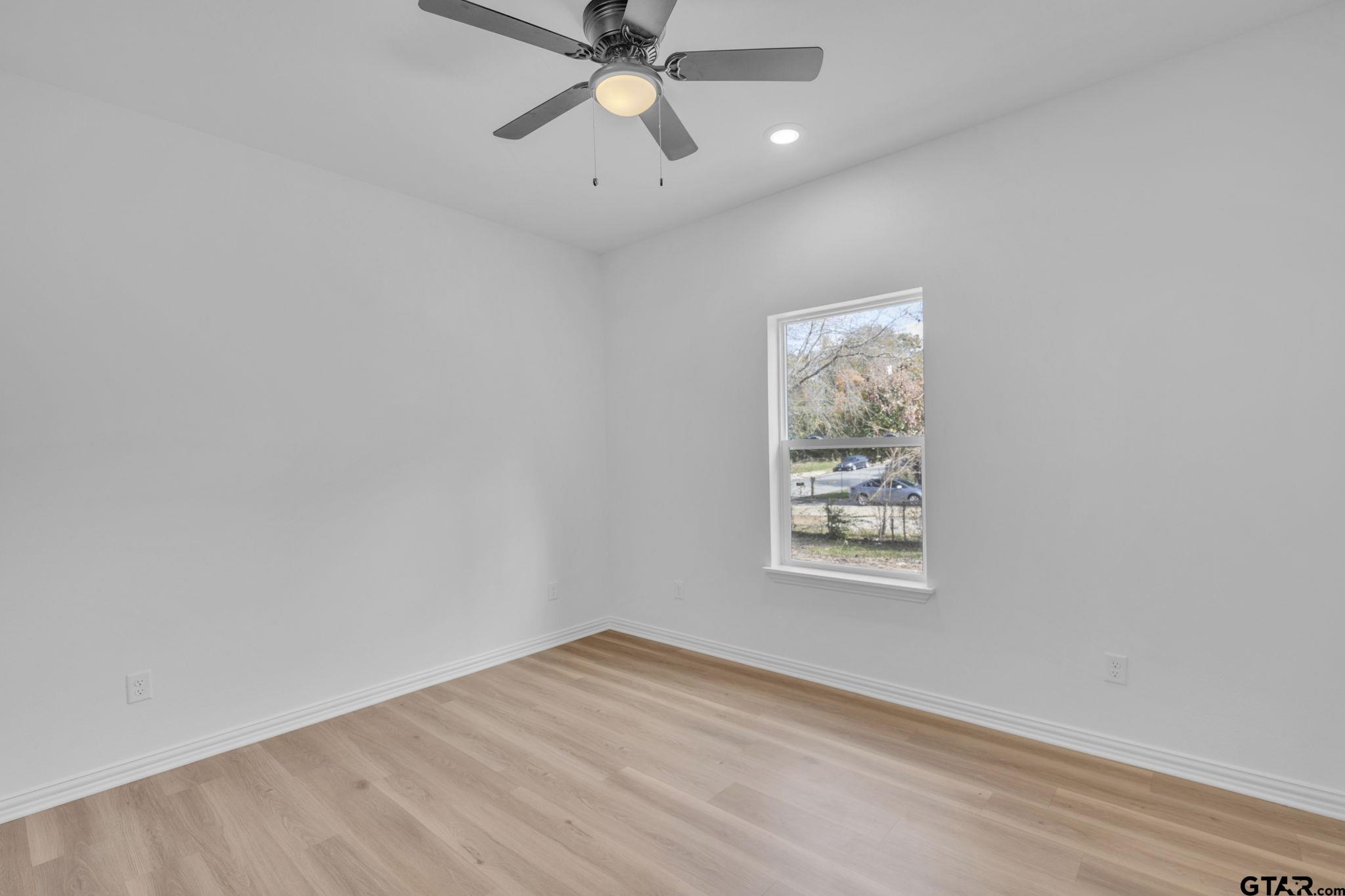 1410 West Connally Street Tyler, TX 75701 - Photo 13 of 29 an empty room with a window and ceiling fan