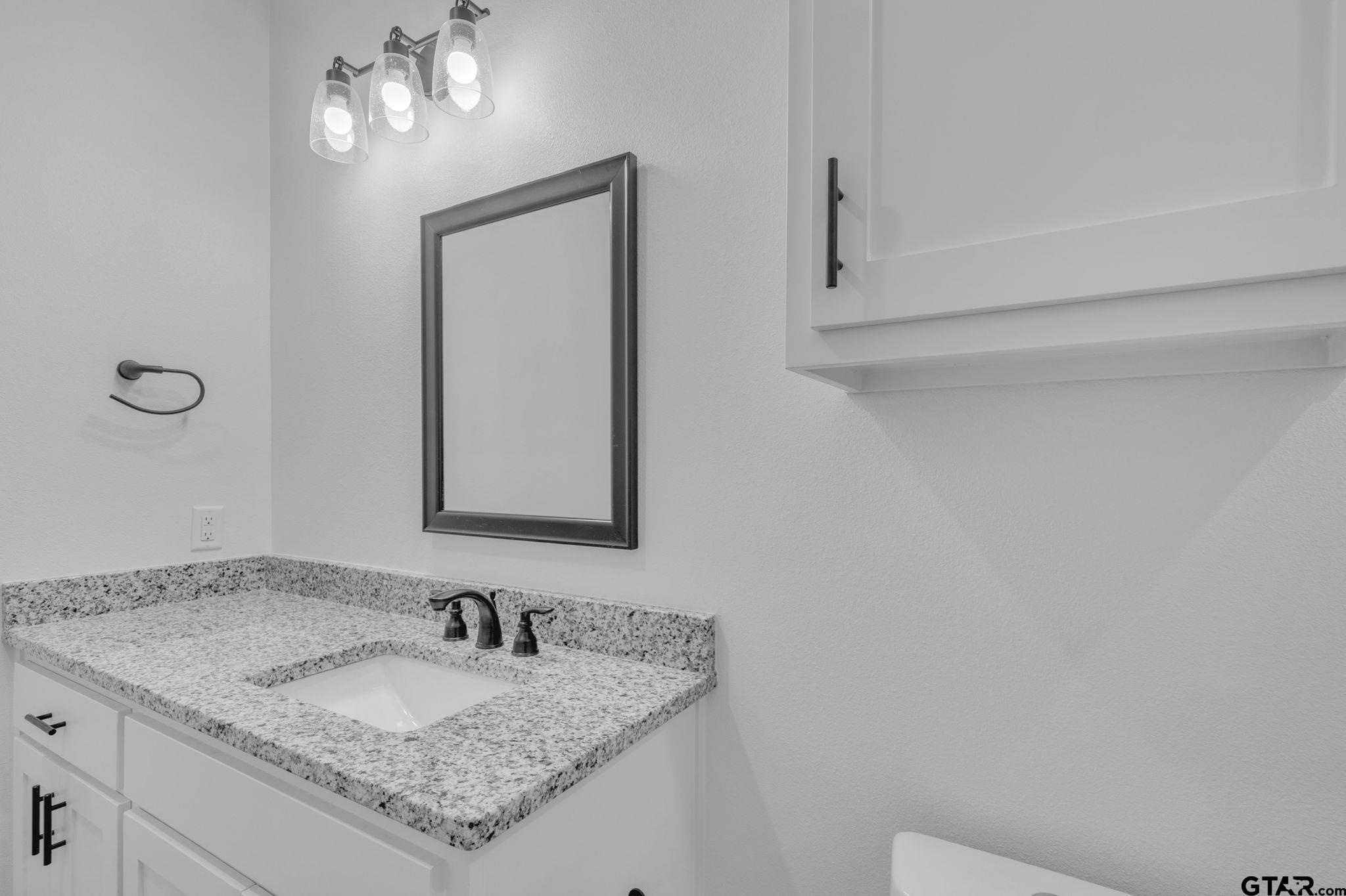 1410 West Connally Street Tyler, TX 75701 - Photo 15 of 29 a bathroom with a granite countertop sink and a mirror