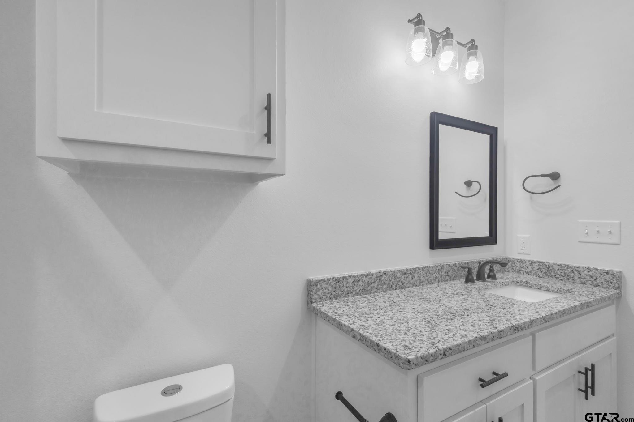 1410 West Connally Street Tyler, TX 75701 - Photo 23 of 29 a bathroom with a granite countertop sink and a mirror