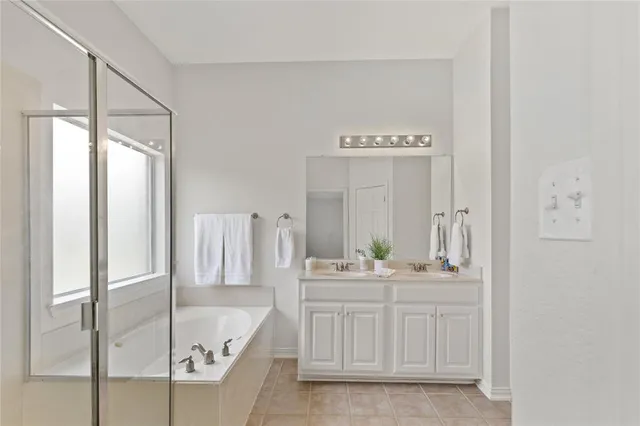 a bathroom with a granite countertop tub sink and mirror
