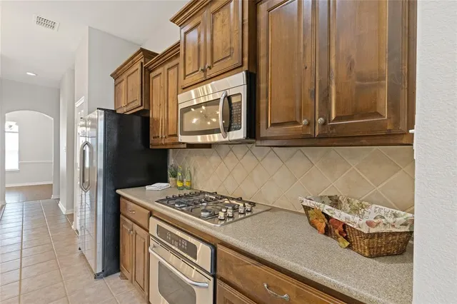a kitchen with stainless steel appliances granite countertop a refrigerator and a stove