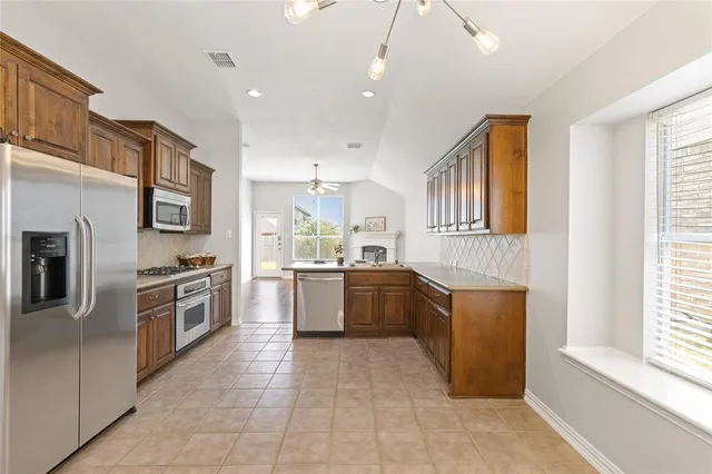 a large kitchen with stainless steel appliances granite countertop a large stove top oven a sink dishwasher and a refrigerator