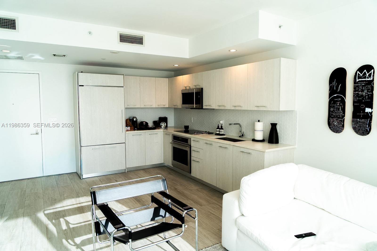 55 Southwest 9th Street, Unit 3607 Miami, FL 33130 - Photo 12 of 15 a kitchen with a refrigerator a sink and cabinets