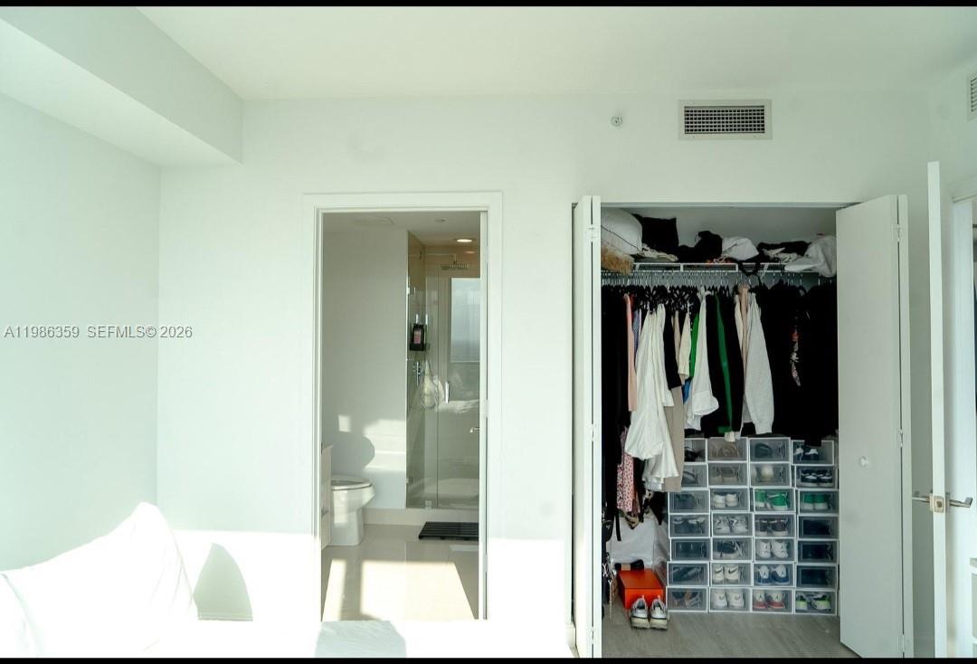 55 Southwest 9th Street, Unit 3607 Miami, FL 33130 - Photo 15 of 15 a view of walk in closet with clothes and shoes