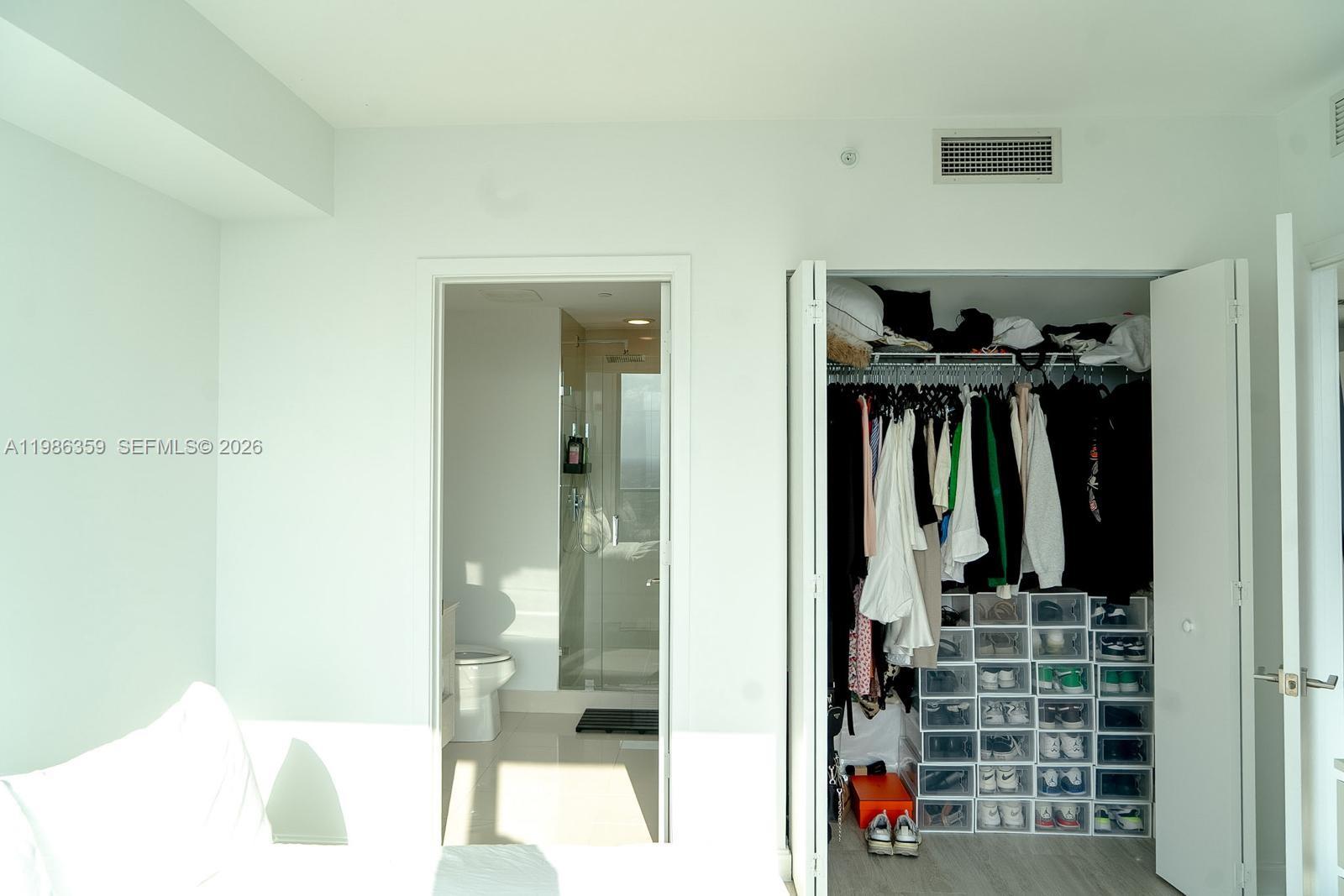 55 Southwest 9th Street, Unit 3607 Miami, FL 33130 - Photo 4 of 15 a view of walk in closet with clothes and shoes