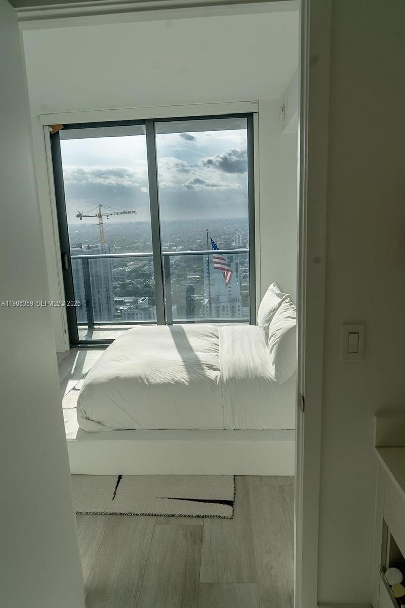 55 Southwest 9th Street, Unit 3607 Miami, FL 33130 - Photo 5 of 15 a bed sitting in a bedroom next to a window