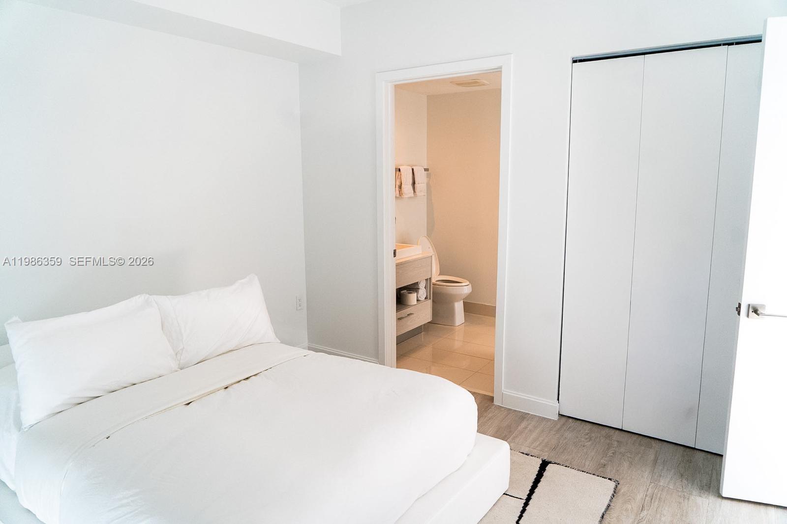 55 Southwest 9th Street, Unit 3607 Miami, FL 33130 - Photo 6 of 15 a spacious bedroom with a bed and a table