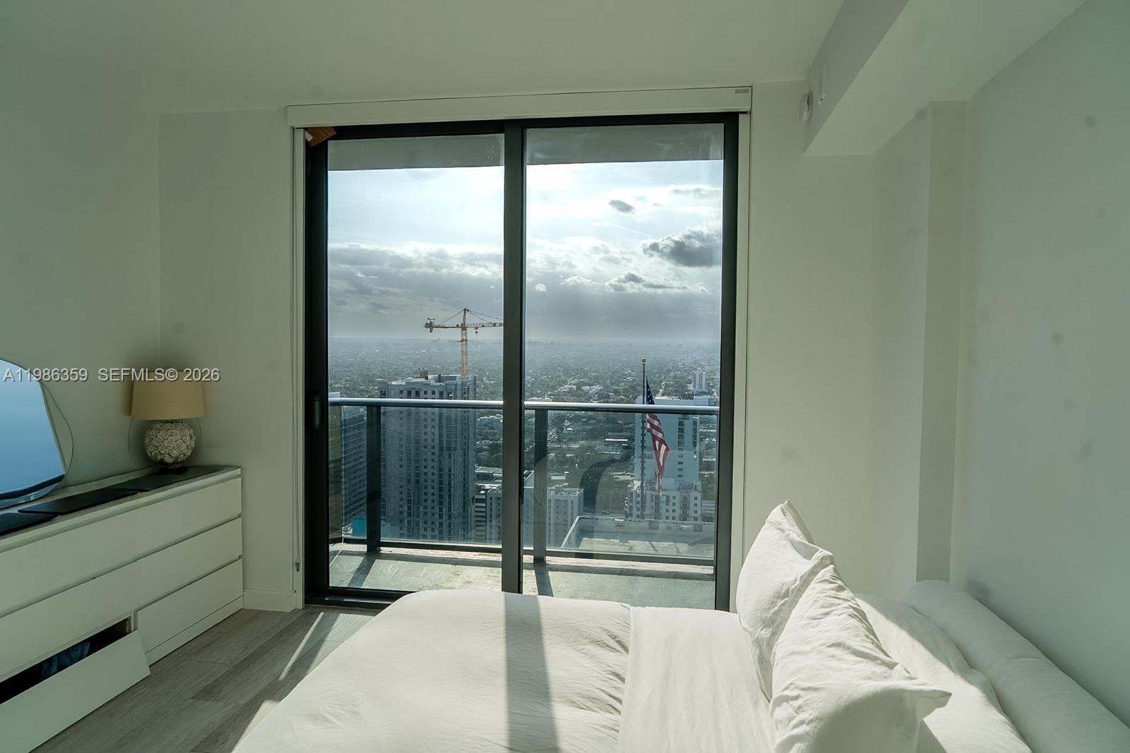 55 Southwest 9th Street, Unit 3607 Miami, FL 33130 - Photo 7 of 15 a bedroom with a bed and a large window