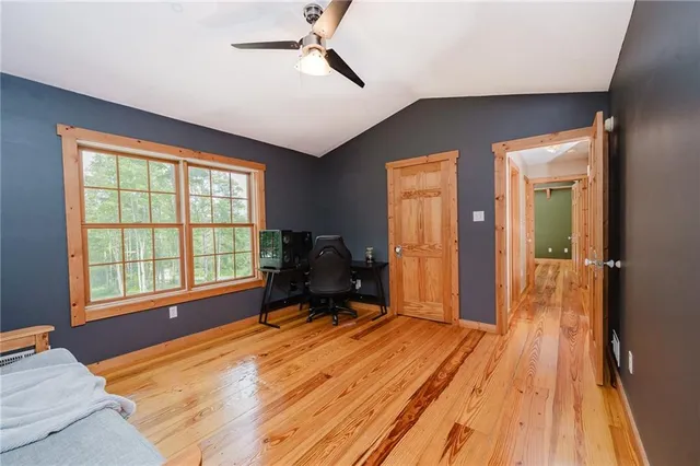a bedroom with a bed dresser and a large window