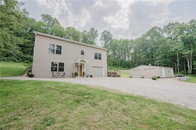 a view of a house with backyard and trees