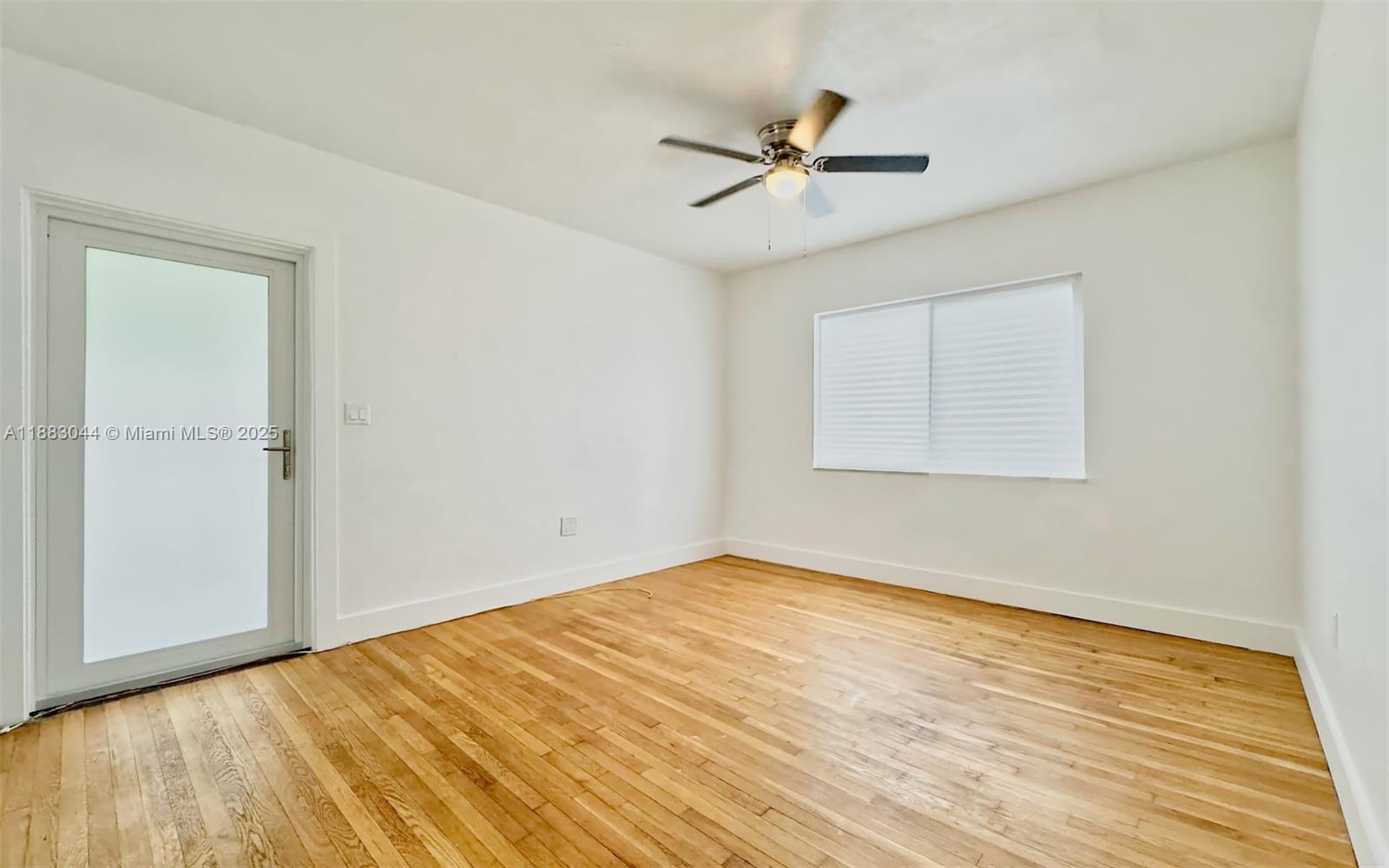 3770 Southwest 27th Street, Unit 3772 Miami, FL 33134 - Photo 2 of 15 a view of an empty room with wooden floor and a window