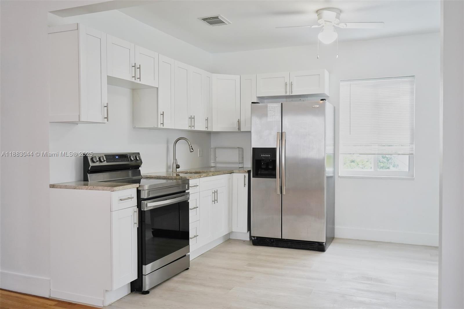 3770 Southwest 27th Street, Unit 3772 Miami, FL 33134 - Photo 3 of 15 a kitchen with stainless steel appliances a refrigerator a stove a white cabinet and white cabinets
