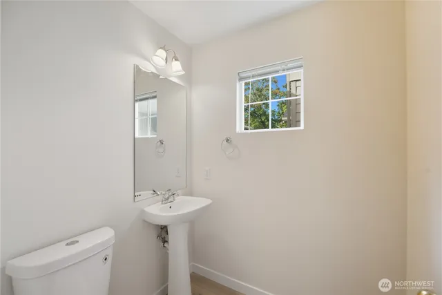 a bathroom with a sink a toilet and a window