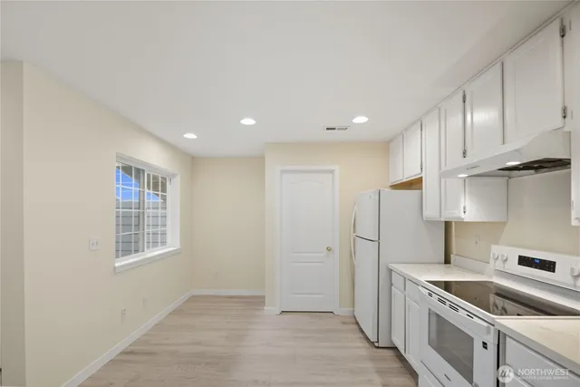 a kitchen with stainless steel appliances granite countertop a sink and a refrigerator