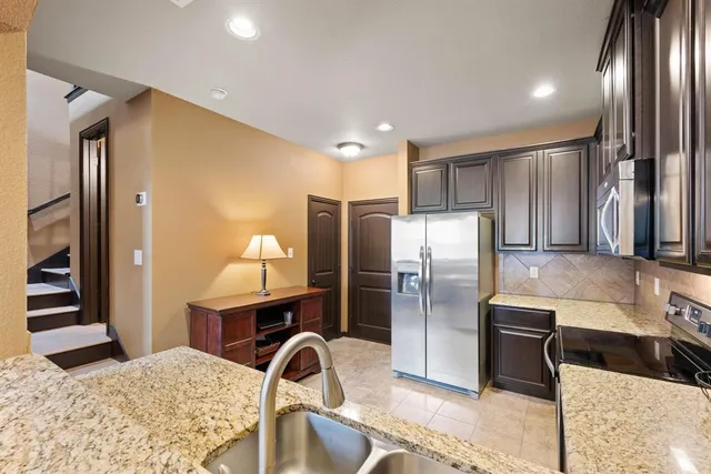 a kitchen with stainless steel appliances kitchen island granite countertop a refrigerator and stove