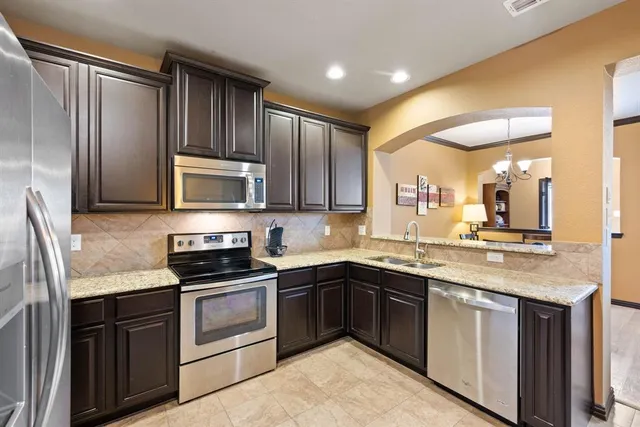 a kitchen with kitchen island granite countertop stainless steel appliances and sink