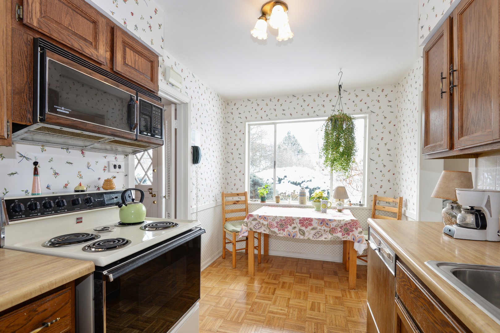 3225 Illinois Road Wilmette, IL 60091 - Photo 11 of 21 a kitchen with a stove a sink and a microwave