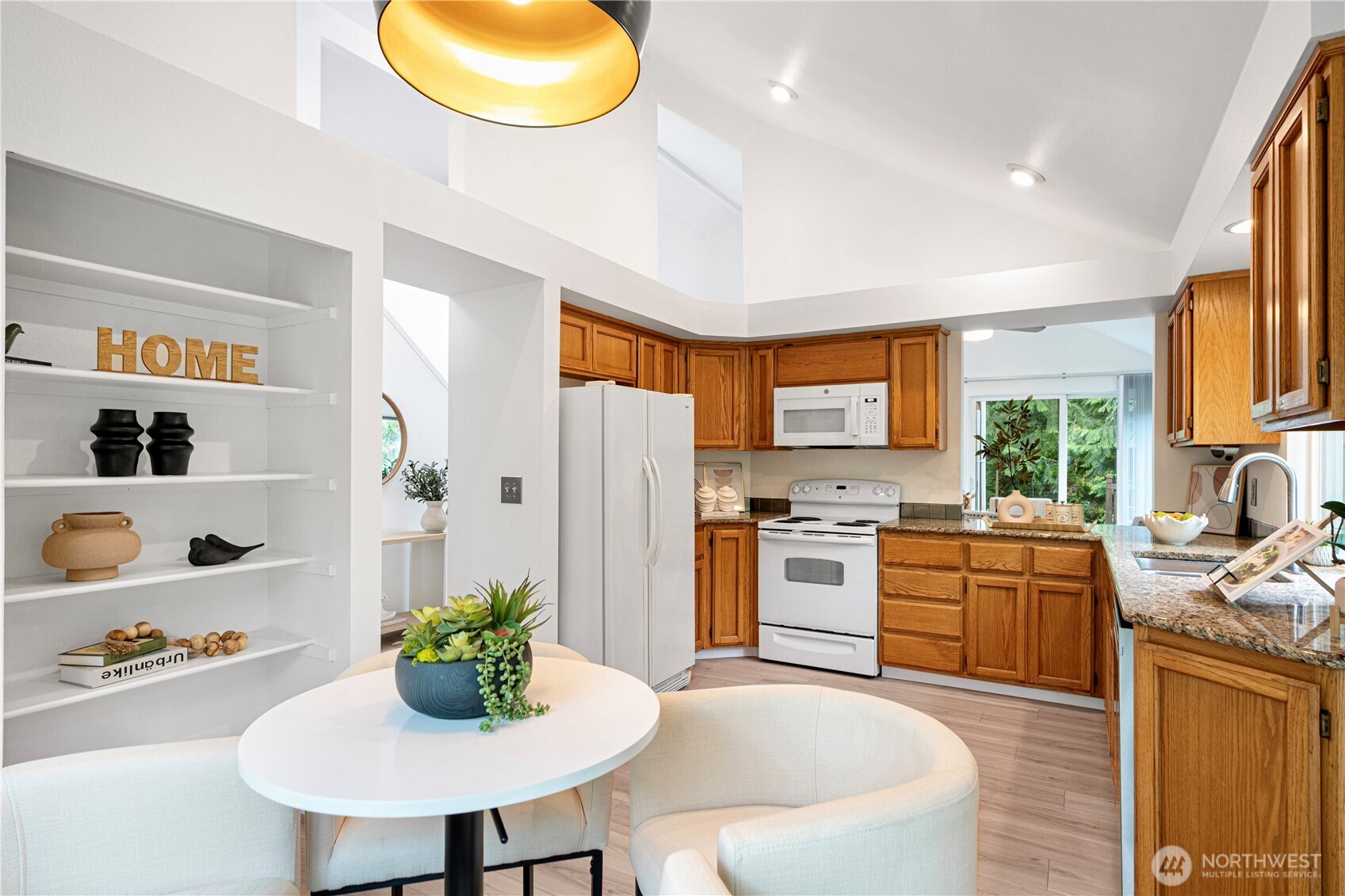 11719 Northeast 166th Court Bothell, WA 98011 - Photo 8 of 27 a kitchen with stove refrigerator dining table and chairs