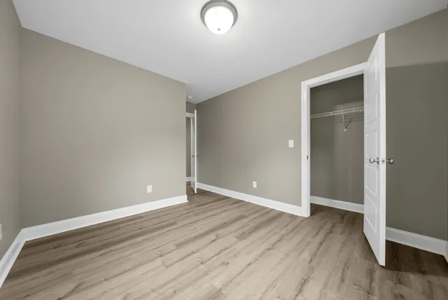an empty room with wooden floor and closet