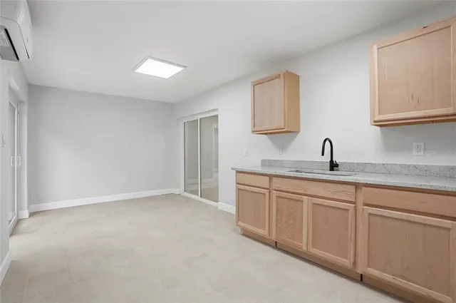 a kitchen with granite countertop white cabinets and sink