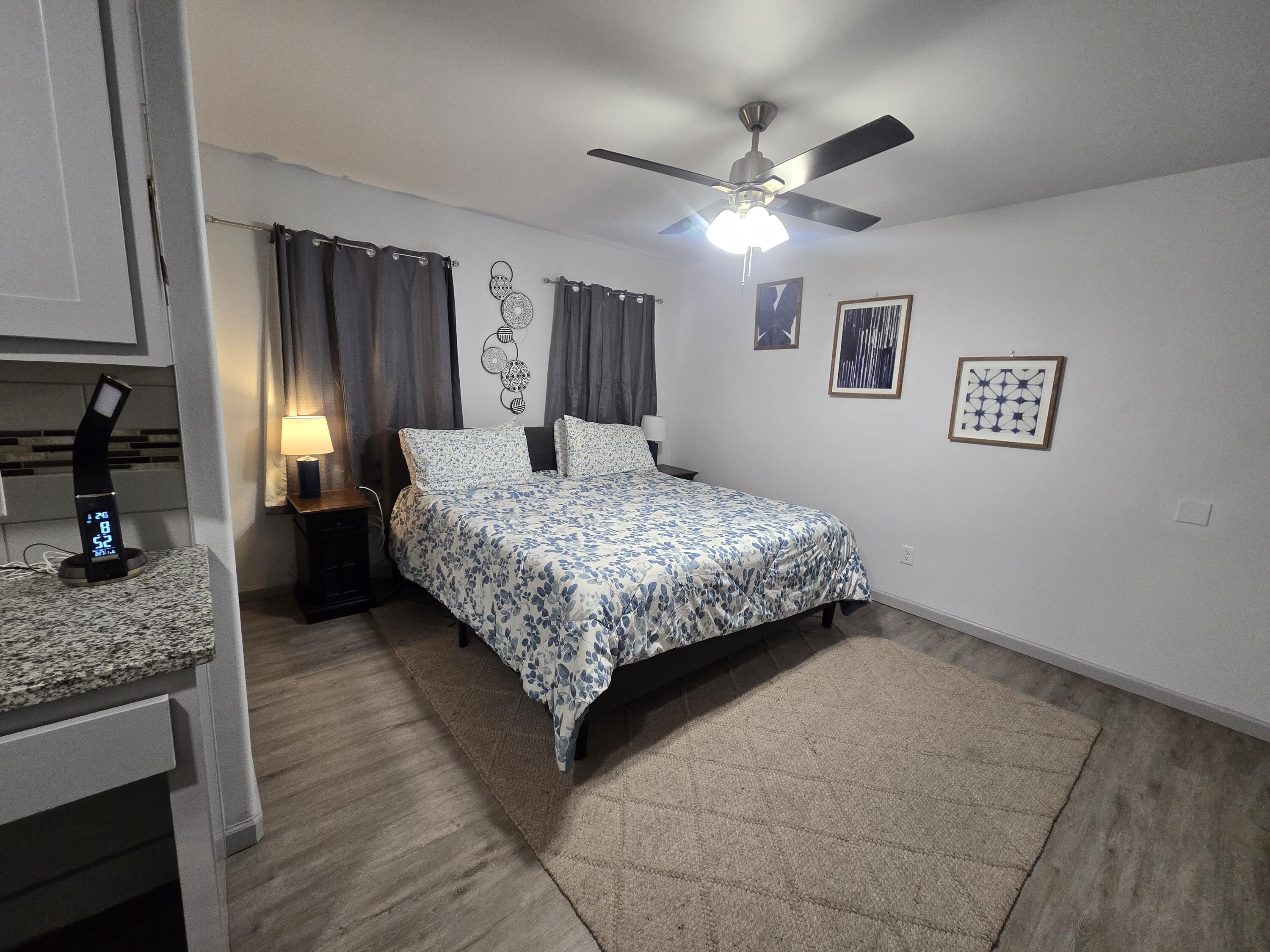 3809 36th Street, Unit A Lubbock, TX 79413 - Photo 2 of 9 a bedroom with a large bed and a chandelier