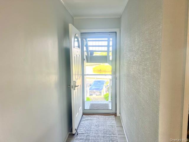 35 Library Avenue, Unit 6J Westhampton Beach, NY 11978 - Photo 5 of 19 Entryway featuring ornamental molding and wood finished floors