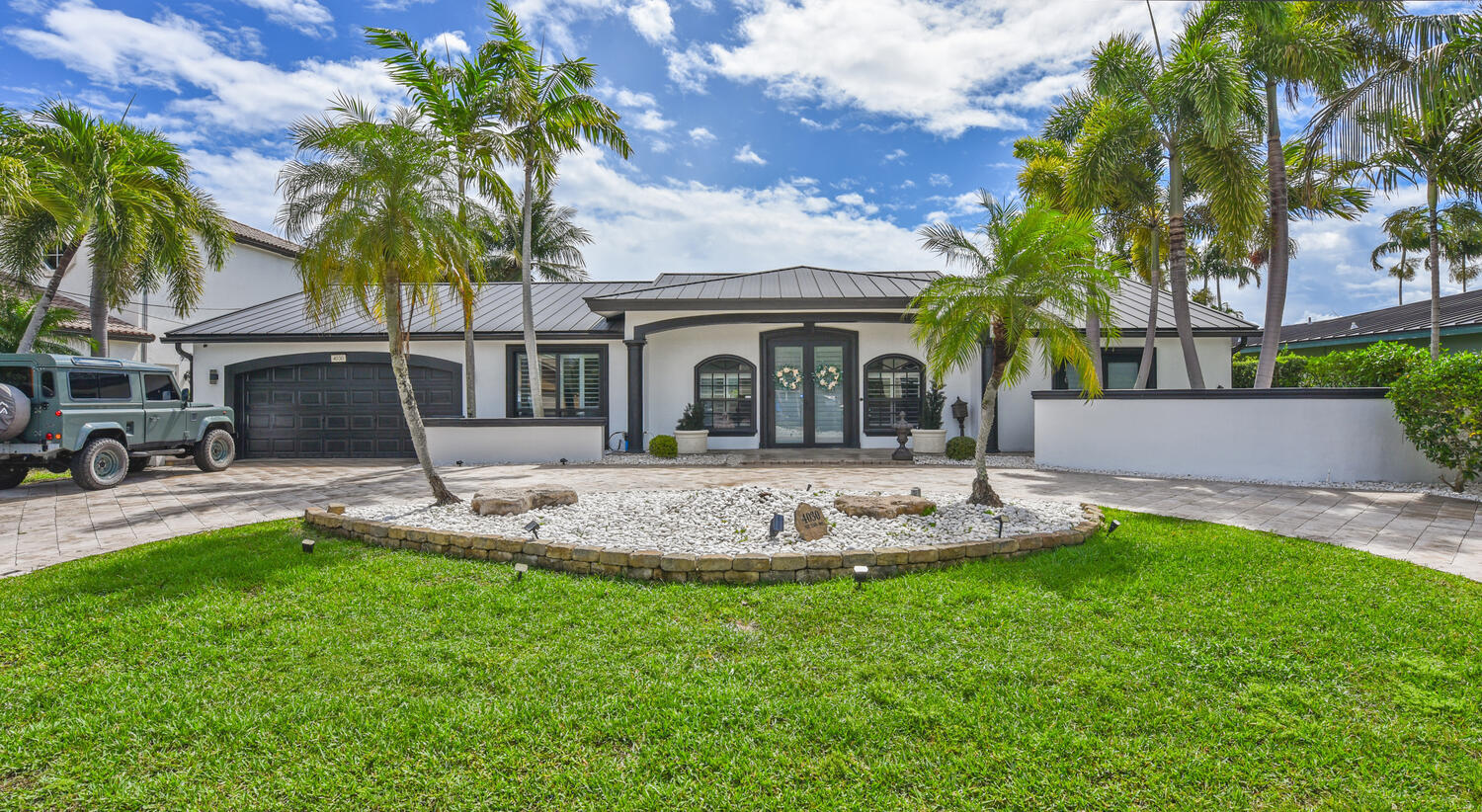 4030 Northeast 25th Avenue Lighthouse Point, FL 33064 - Photo 3 of 50 a front view of a house with a garden and tree