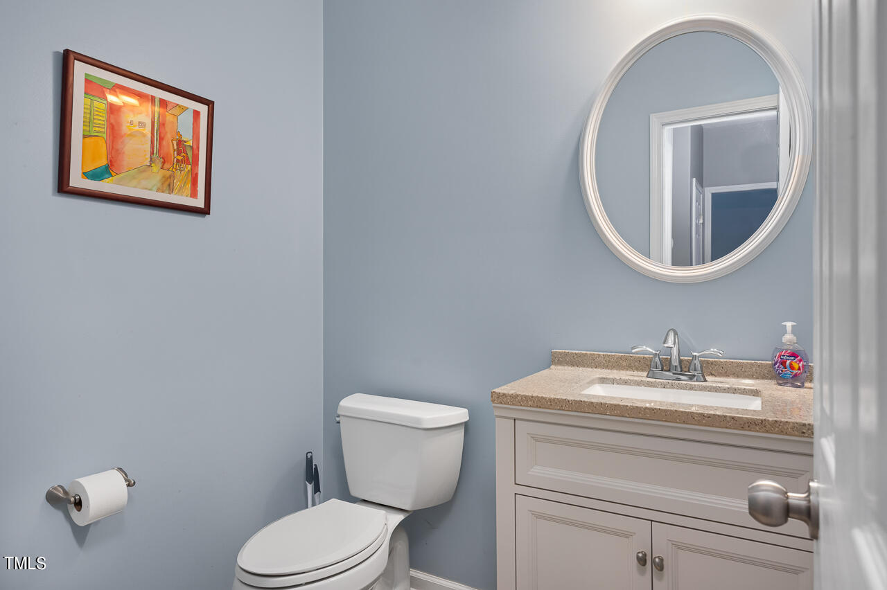 704 Nightshade Way Raleigh, NC 27610 - Photo 14 of 39 a bathroom with a toilet sink vanity and mirror