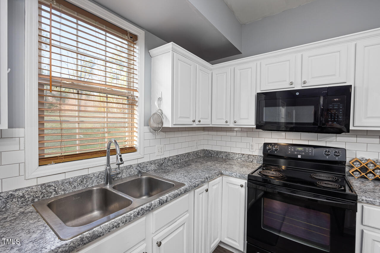 704 Nightshade Way Raleigh, NC 27610 - Photo 18 of 39 a kitchen with a stove and a microwave