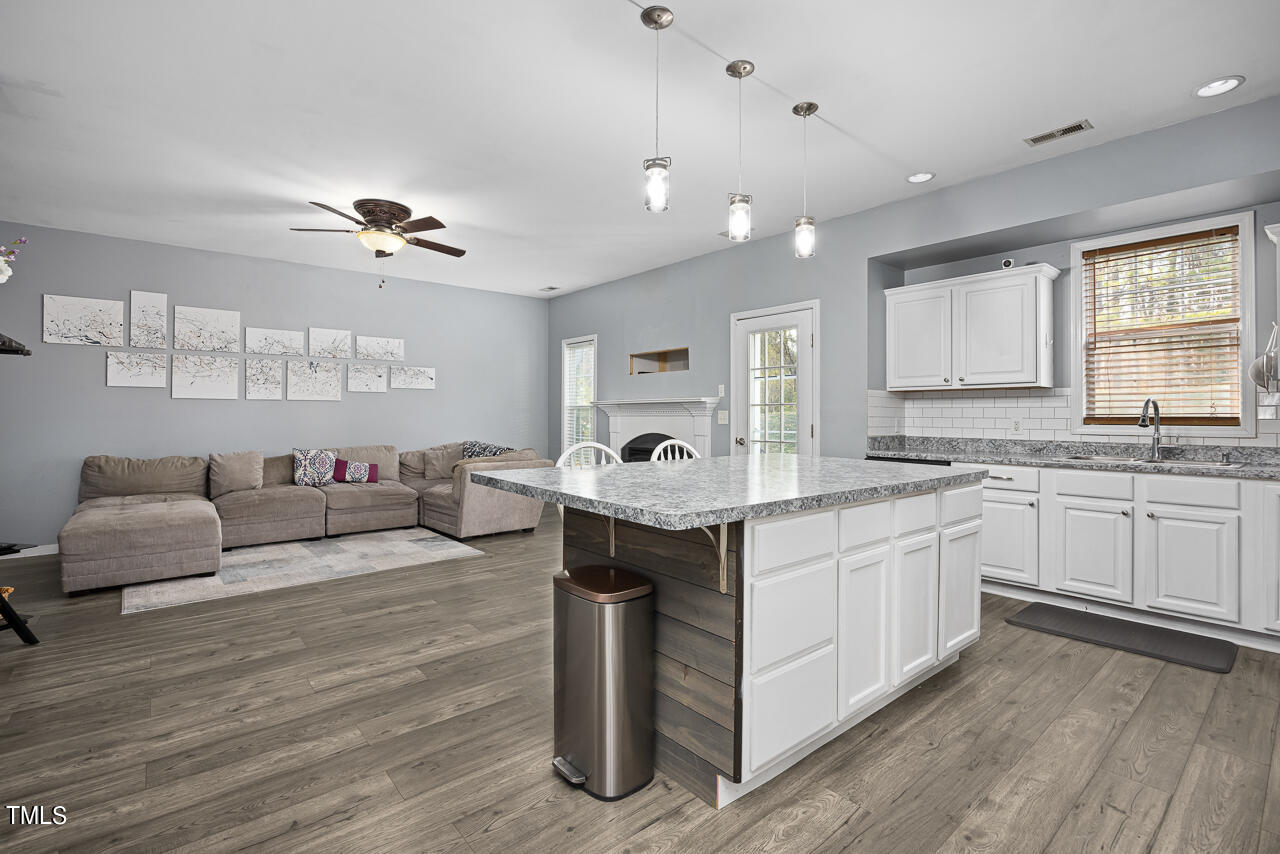 704 Nightshade Way Raleigh, NC 27610 - Photo 19 of 39 a large living room with stainless steel appliances granite countertop furniture and a wooden floors