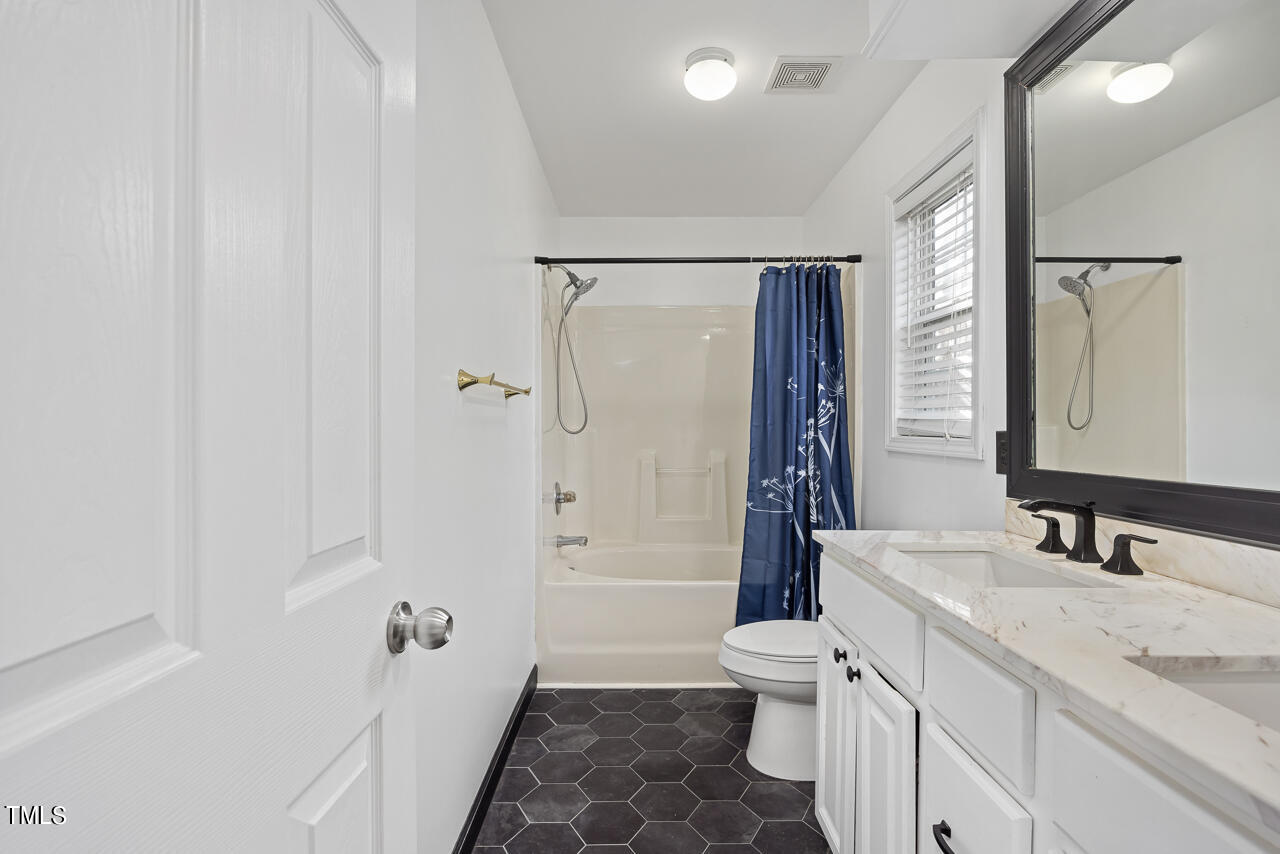704 Nightshade Way Raleigh, NC 27610 - Photo 24 of 39 a bathroom with a granite countertop sink toilet and shower