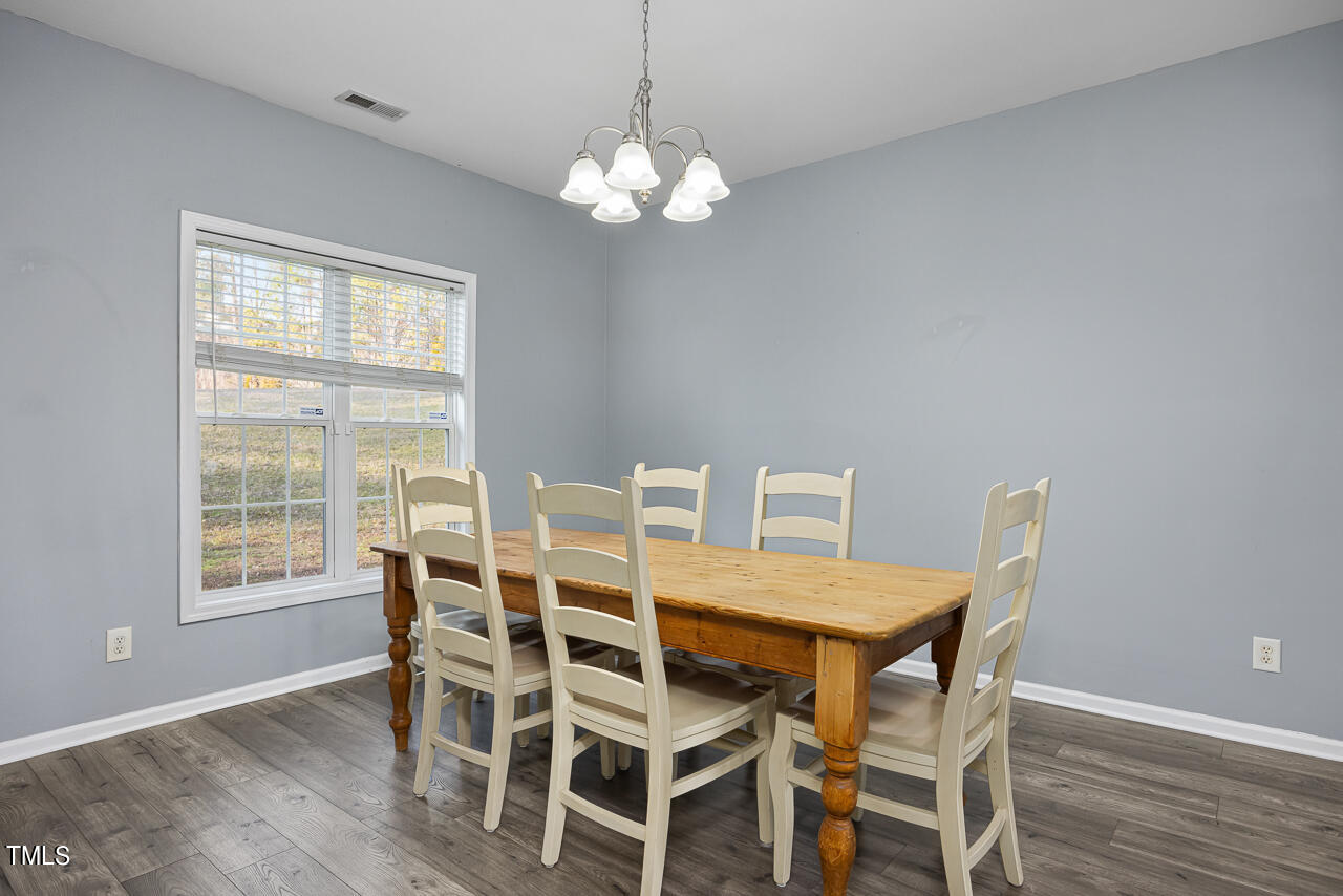 704 Nightshade Way Raleigh, NC 27610 - Photo 10 of 39 a view of a dining room with furniture and wooden floor