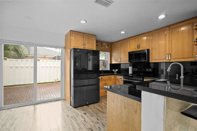 a kitchen with stainless steel appliances granite countertop a refrigerator and a stove top oven
