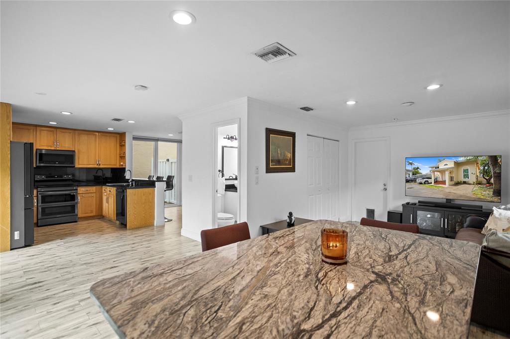 9837 Northwest 2nd Court Plantation, FL 33324 - Photo 20 of 69 a large kitchen with stainless steel appliances kitchen island granite countertop a refrigerator and a stove top oven